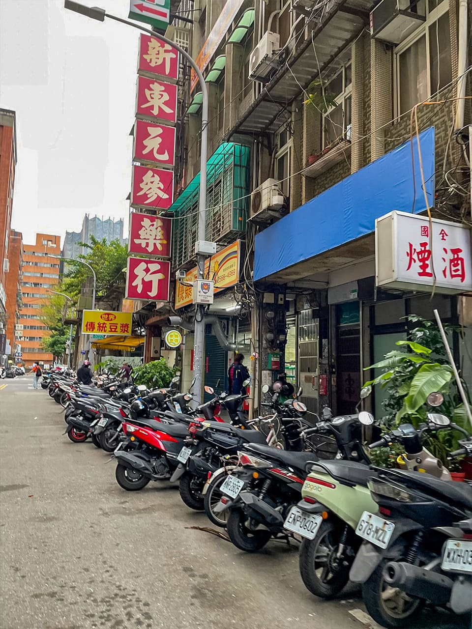 オートバイがずらりと並ぶ住宅街の角にある世界豆浆大王