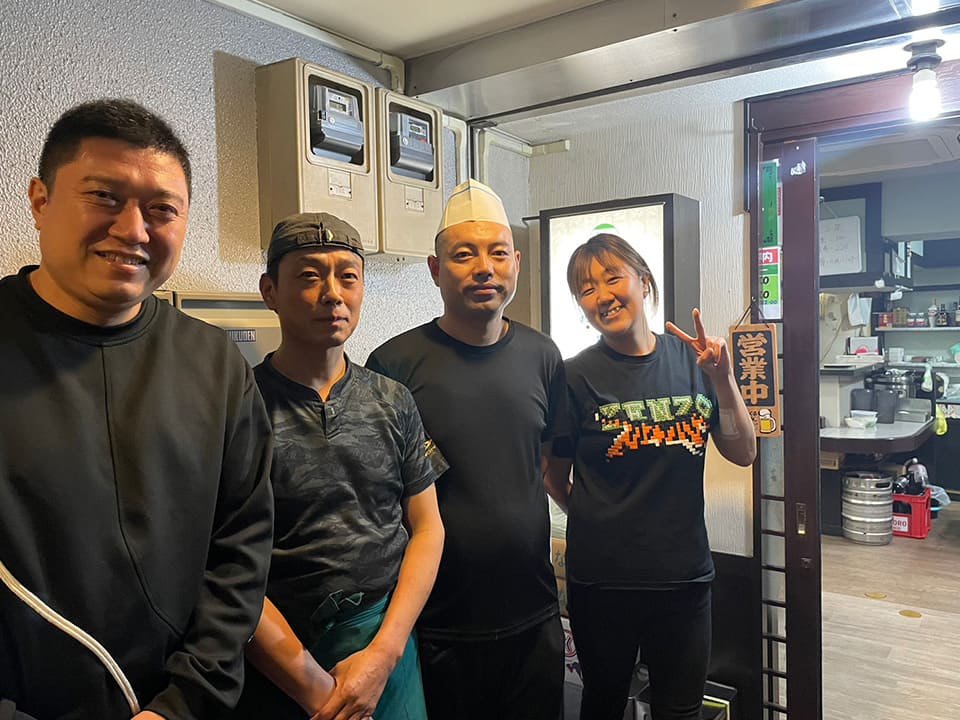 写真は従業員の方々。左から順に店長の牟明輝さん、胡鹏さん、白鋼さん、劉健さん