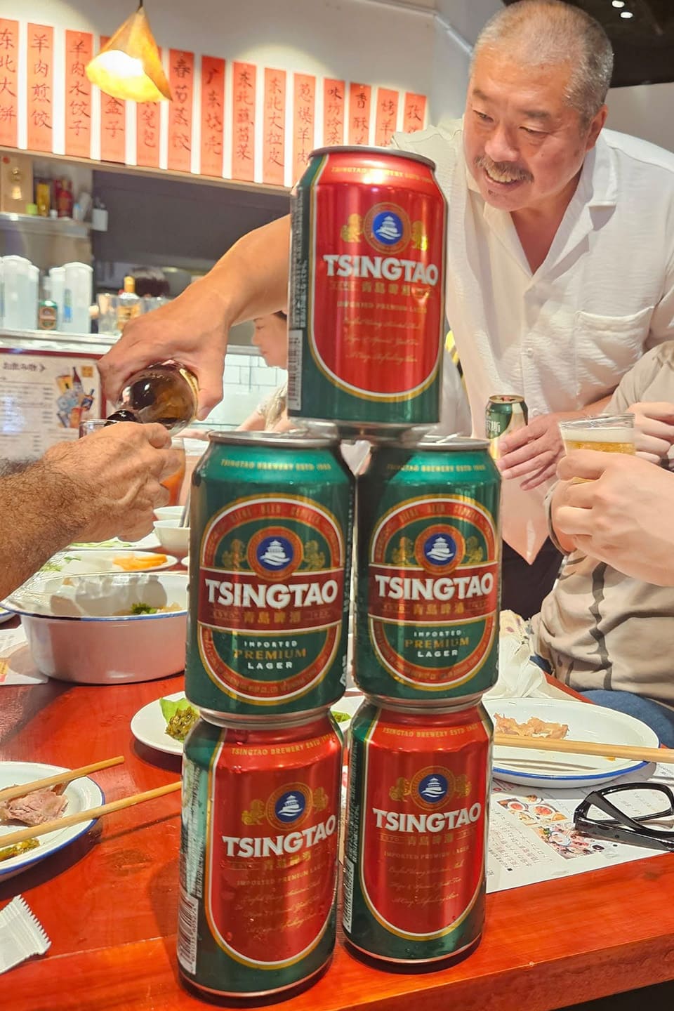 笑顔で皆さんにビールを注いで回る梁さん