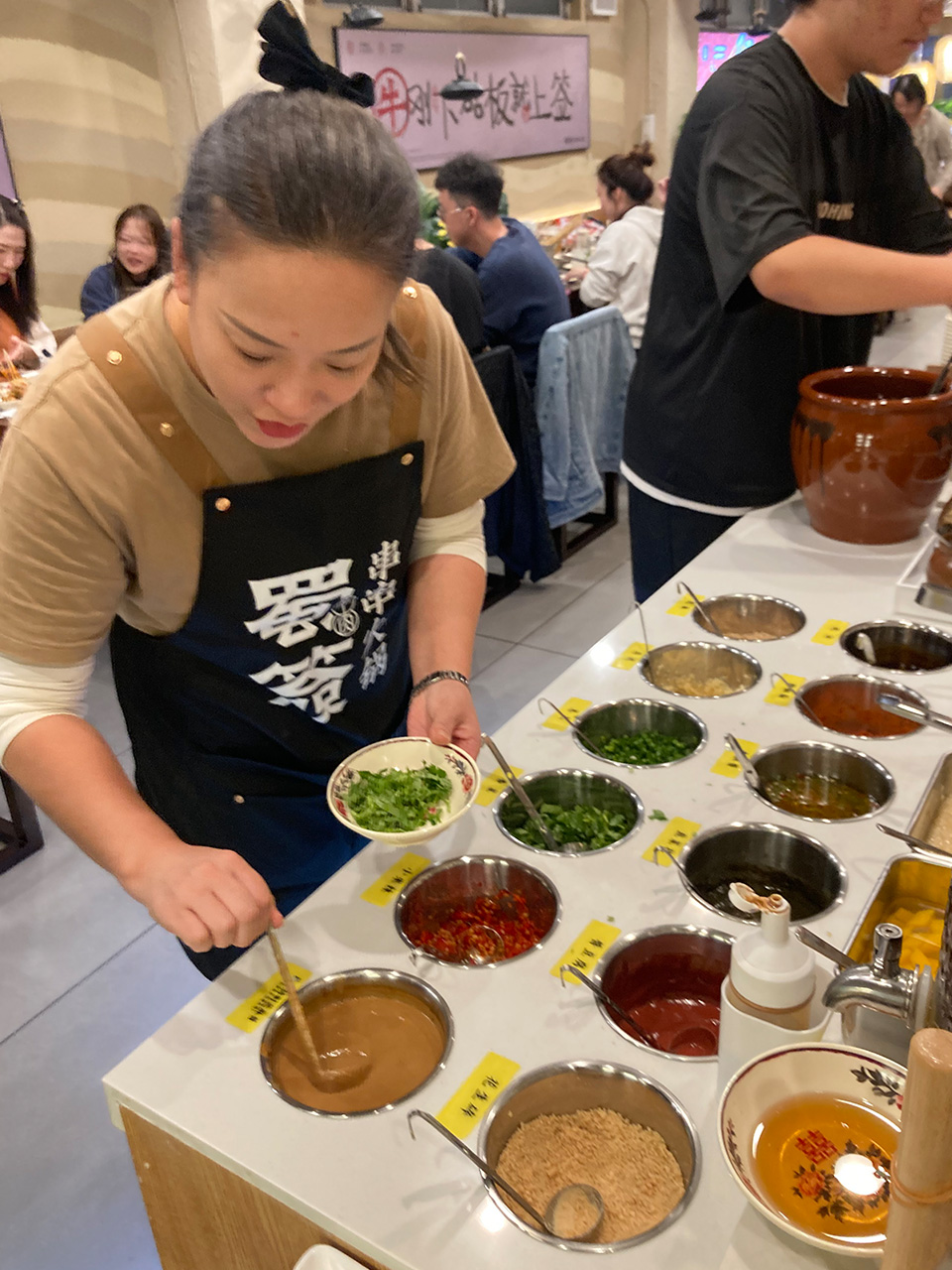 「串串香(チュアンチュアンシャン)」たれを丁寧に作ってくれる店員さん