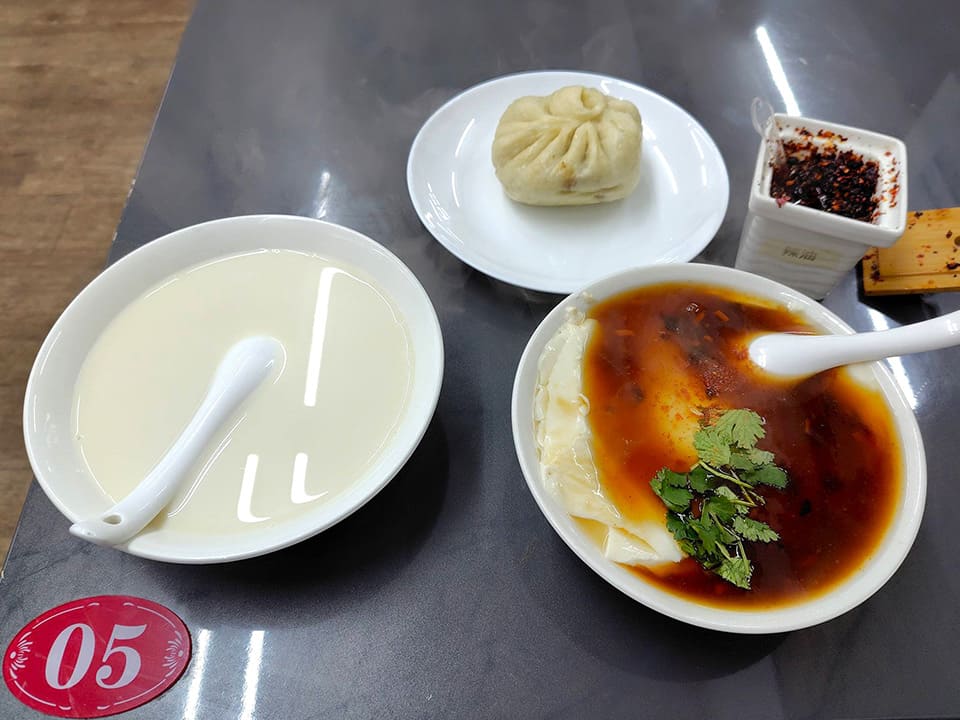 左から豆乳、中央が牛肉まん、右が豆腐脑。四角い入れ物に入っているのは自家製ラー油